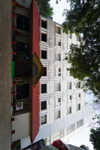 a tall white building with red and white windows at Hotel Palmyra Grand Inn in Tirunelveli