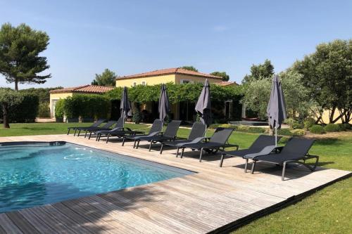 - un groupe de chaises longues et de parasols à côté de la piscine dans l'établissement Villa Oasis Luxury and Relaxation in Provence, à Lambesc
