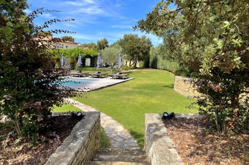 un jardin avec une piscine, des bancs et des arbres dans l'établissement Villa Oasis Luxury and Relaxation in Provence, à Lambesc