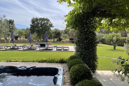 une piscine d'eau dans un parc avec des bancs et des tables dans l'établissement Villa Oasis Luxury and Relaxation in Provence, à Lambesc