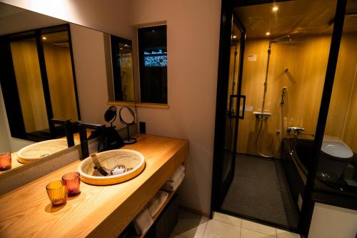 a bathroom with a sink and a shower at Auberge Homachi Mikuniminato in Sakai