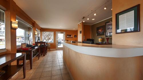 a restaurant with a bar and some tables and chairs at Campus Inn & Suites Eugene Downtown in Eugene