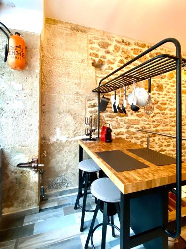 une cuisine avec une table et des tabourets dans une pièce dans l'établissement #SPA Wellness @ Paris 11ème, à Paris