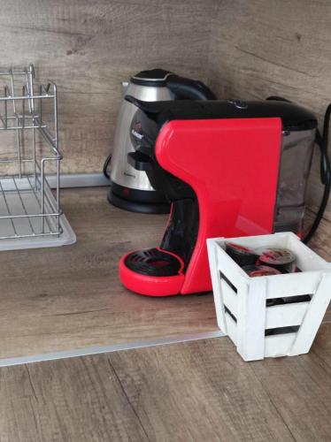 a red mixer sitting on the floor next to a basket at DiP HOME APARTMENTS in Pomorie