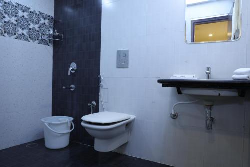 a bathroom with a toilet and a sink at HOTEL SR in Palani
