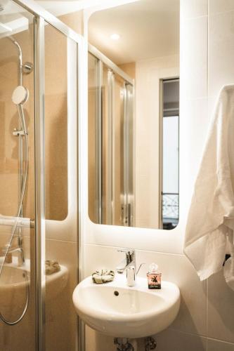 une salle de bain avec un lavabo, une douche et un miroir dans l'établissement La Maison Montparnasse, à Paris