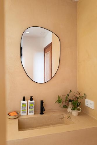 a bathroom with a mirror and a sink at Can Arabí - Adults Only in Ibiza Town