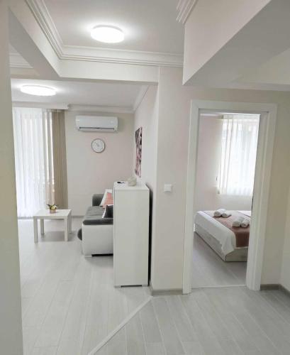 a white room with a bed and a refrigerator at DiP HOME APARTMENTS in Pomorie