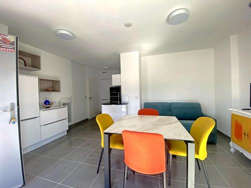 eine Küche und ein Esszimmer mit einem Tisch und Stühlen in der Unterkunft RÉF 256 - LARMOR-PLAGE T2 en RDC plein bourg avec terrasse sur rue principale et parking in Larmor-Plage
