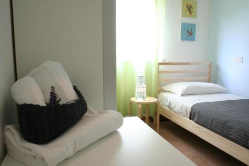 a bedroom with a bed and a chair with towels at Guest House Parco del Mulino in Livorno