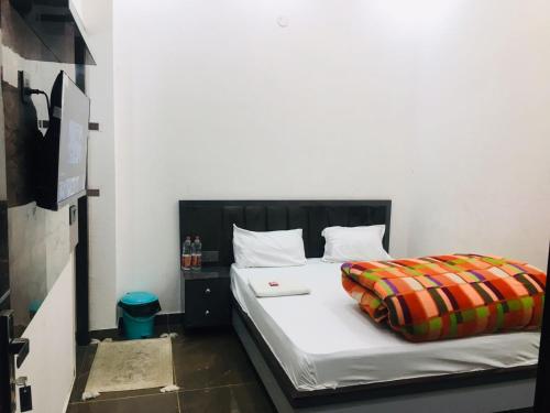Schlafzimmer mit einem Bett mit weißer Bettwäsche in der Unterkunft RV Lodge in Bulandshahr