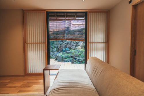 a couch sitting in a room with a window at Auberge Homachi Mikuniminato in Sakai