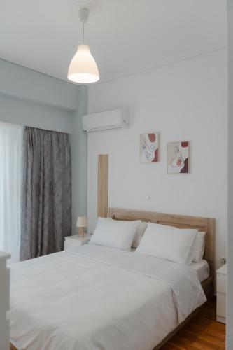 a bedroom with a large bed with white sheets at G & K Cozy Apartments in Athens
