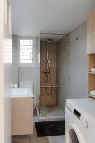 a bathroom with a shower and a sink and a washing machine at G & K Cozy Apartments in Athens