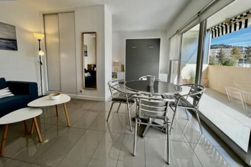 une salle à manger avec une table et des chaises en verre dans l'établissement Studio Cresp Palm Beach, à Cannes