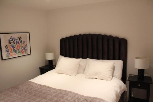 a bedroom with a bed with a large black headboard at Studio Hamra in Särö
