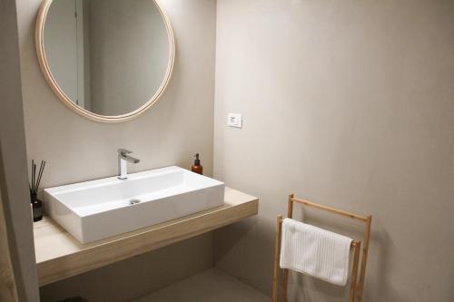 y baño con lavabo blanco y espejo. en Waterfront balcony I Grani 2 Resort Style Suite en Livorno