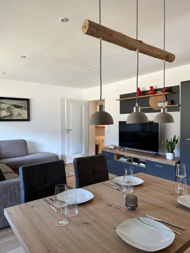 a dining room with a table and a living room at Apartment Schwinbachblick mit 2 Balkonen in St. Blasien