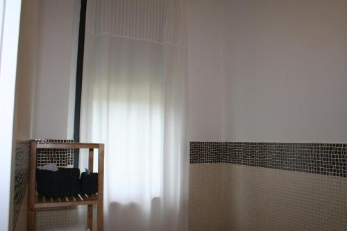 a shower with a white curtain in a bathroom at Guest House Parco del Mulino in Livorno