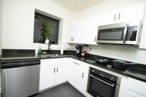 een keuken met witte kasten en een magnetron bij Lovely 2 Bedroom Condo Across from Horse Track condo in Hot Springs