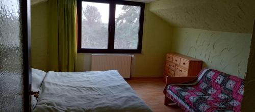 - une chambre avec un lit, une chaise et une fenêtre dans l'établissement Haus-Irmgard, à Neu Schloen