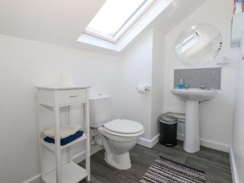 a white bathroom with a toilet and a sink at Victorian Town House in Weymouth