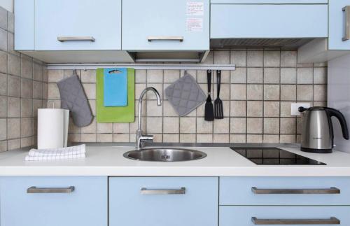 a kitchen with white cabinets and a sink at Portobello Apartments in Bologna