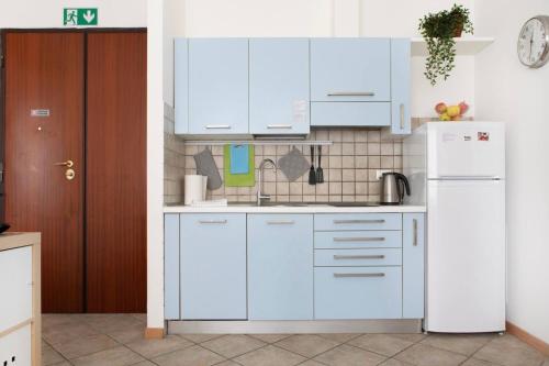 a kitchen with white cabinets and a refrigerator at Portobello Apartments in Bologna
