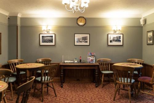 a restaurant with tables and chairs and a clock on the wall at The Red Lion Hotel in Spalding