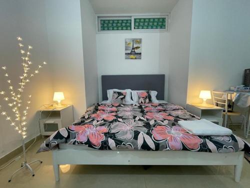- une chambre dotée d'un lit avec un couvre-lit floral dans l'établissement Private Cozy Furnished Studio no 14 Khalidiya Park Villa Abu Dhabi UAE, à Abu Dhabi