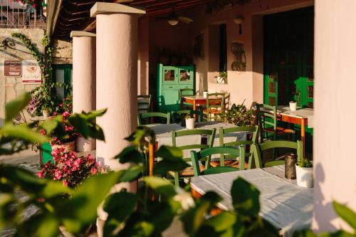 an outdoor restaurant with tables and chairs and flowers at Hiša Štekar in Kojsko