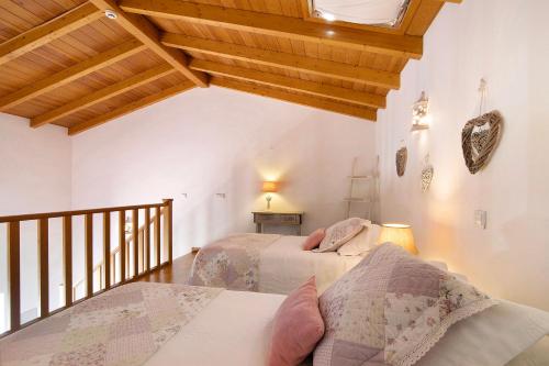 1 dormitorio con 2 camas y techo de madera en Casa Pimenta Rosa, en Alvor