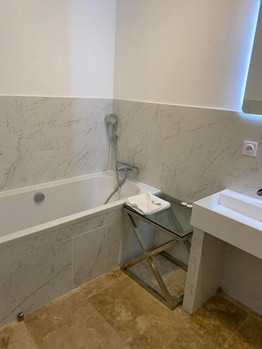 a bathroom with a bath tub and a sink at IKO Bordeaux Appartements in Bordeaux