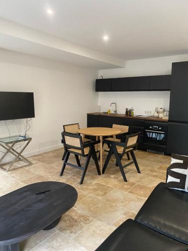 a dining room with a table and chairs and a kitchen at IKO Bordeaux Appartements in Bordeaux