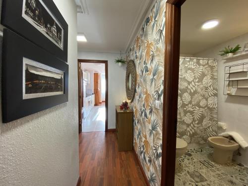 a hallway with a bathroom with a toilet and a wall at Apartamento Cleo Gijón in Gijón