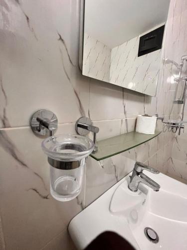 a bathroom with a sink and a mirror at Appartement meublé au virage in Yof