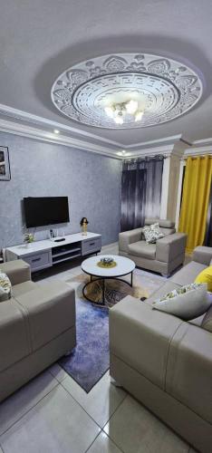 a living room with couches and a flat screen tv at Appartement meublé au virage in Yof