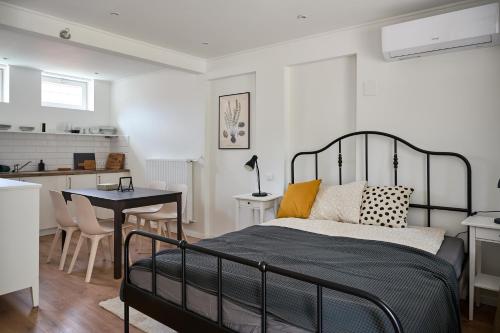 ein Schlafzimmer mit einem Bett und einem Tisch sowie eine Küche in der Unterkunft Kúria apartmanház in Bük