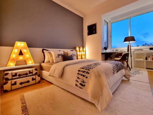 a bedroom with a large bed and a window at NEW - Epic Design -AC, Balcony, Free Parking in Linda-a-Velha