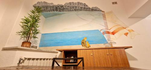 a room with a painting on the wall and a table with a plant at La stella di Manarola- Bluchalet in Manarola