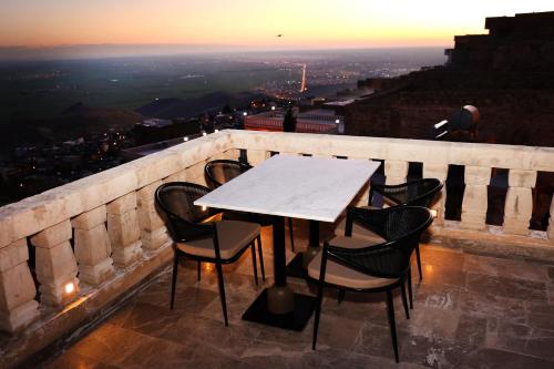una mesa y sillas en una cornisa con vistas en Zabel Hotel, en Mardin