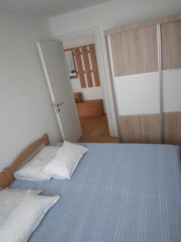 a bedroom with a bed with blue sheets and white pillows at Apartment SUNČICA in Split