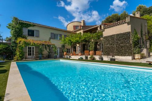 une maison avec une piscine devant une maison dans l'établissement Provencal bastide with heated pool near Alpilles and Luberon, à Vernègues