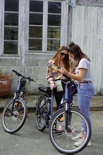 two women are standing next to their bikes at Nawenn locations - maison du bonheur in La Landec
