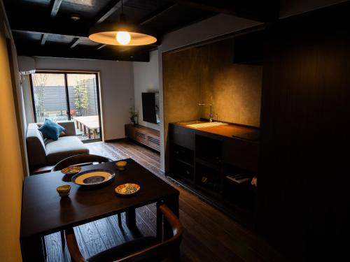 a living room with a table and a couch at Auberge Homachi Mikuniminato in Sakai
