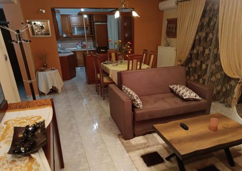 uma sala de estar com um sofá e uma mesa em J&B Home em Alexandroupoli