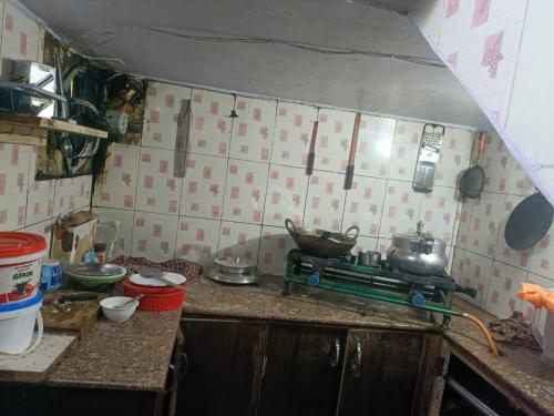 a kitchen with a stove with pots and pans on it at BNB ROYAL INN SHIMLA in Shimla