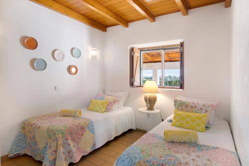 a bedroom with two beds and a window at Casa Laranja Canela in Alvor
