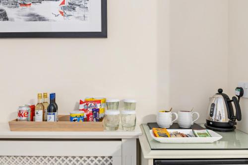 a kitchen with a counter with food and drinks at Kingston House in Torquay