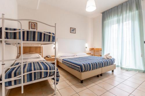 sypialnia z 2 łóżkami piętrowymi i oknem w obiekcie Hotel Vannucci w Rimini
